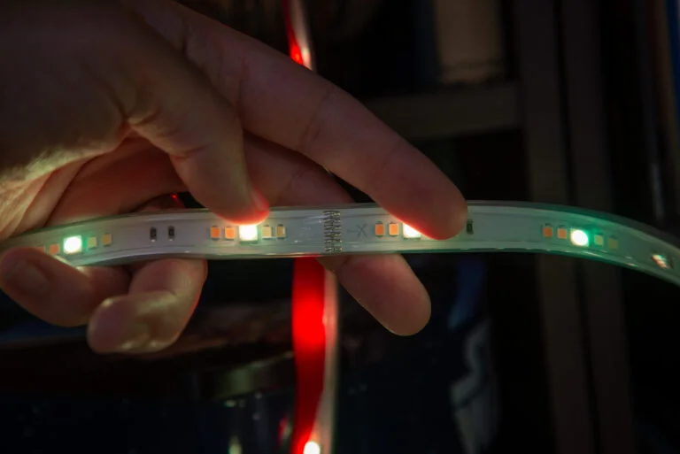 A Technician Using An Led Strip Connector To Join Two Sections Of An Led Strip.