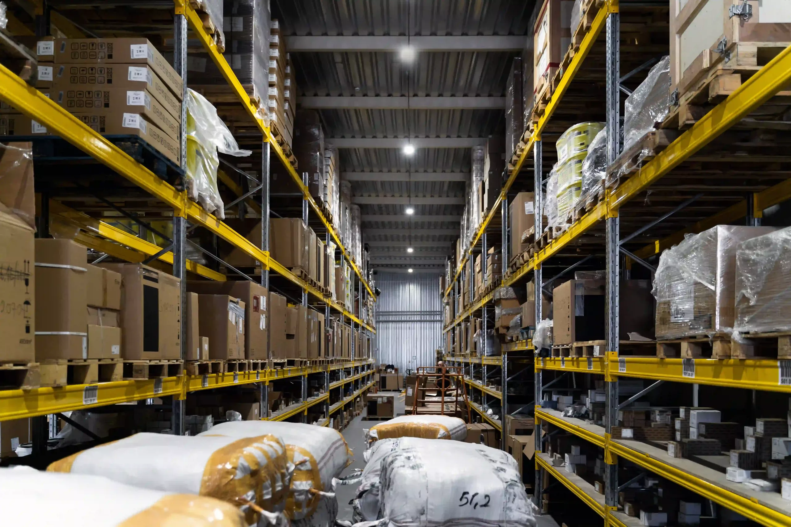 High Efficiency Led High Bay Lights Illuminating A Spacious Warehouse, Ensuring Ample Light Coverage For Large Areas.