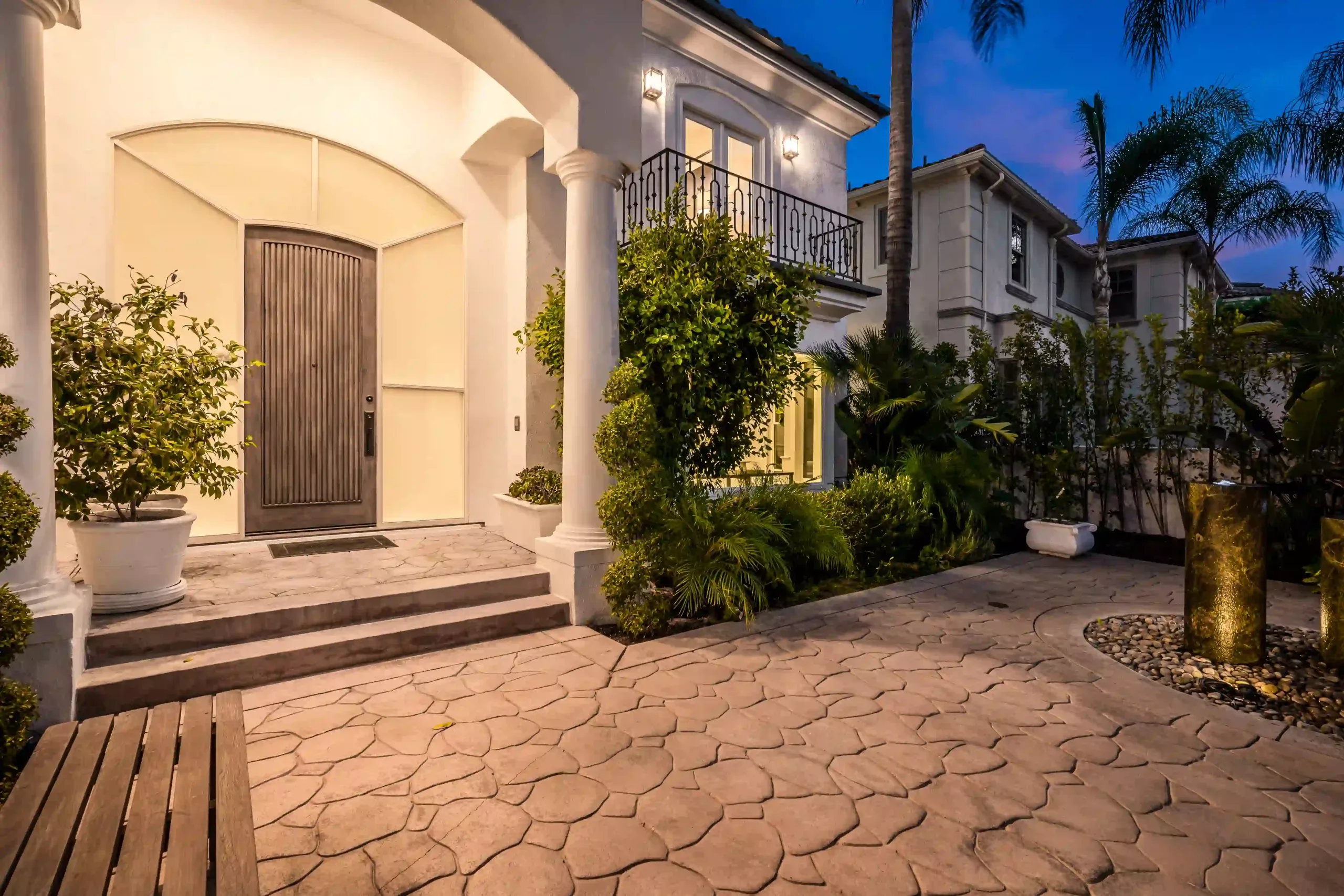 Illuminated Stone Path And Stairs Leading To A House Entrance At Sunset