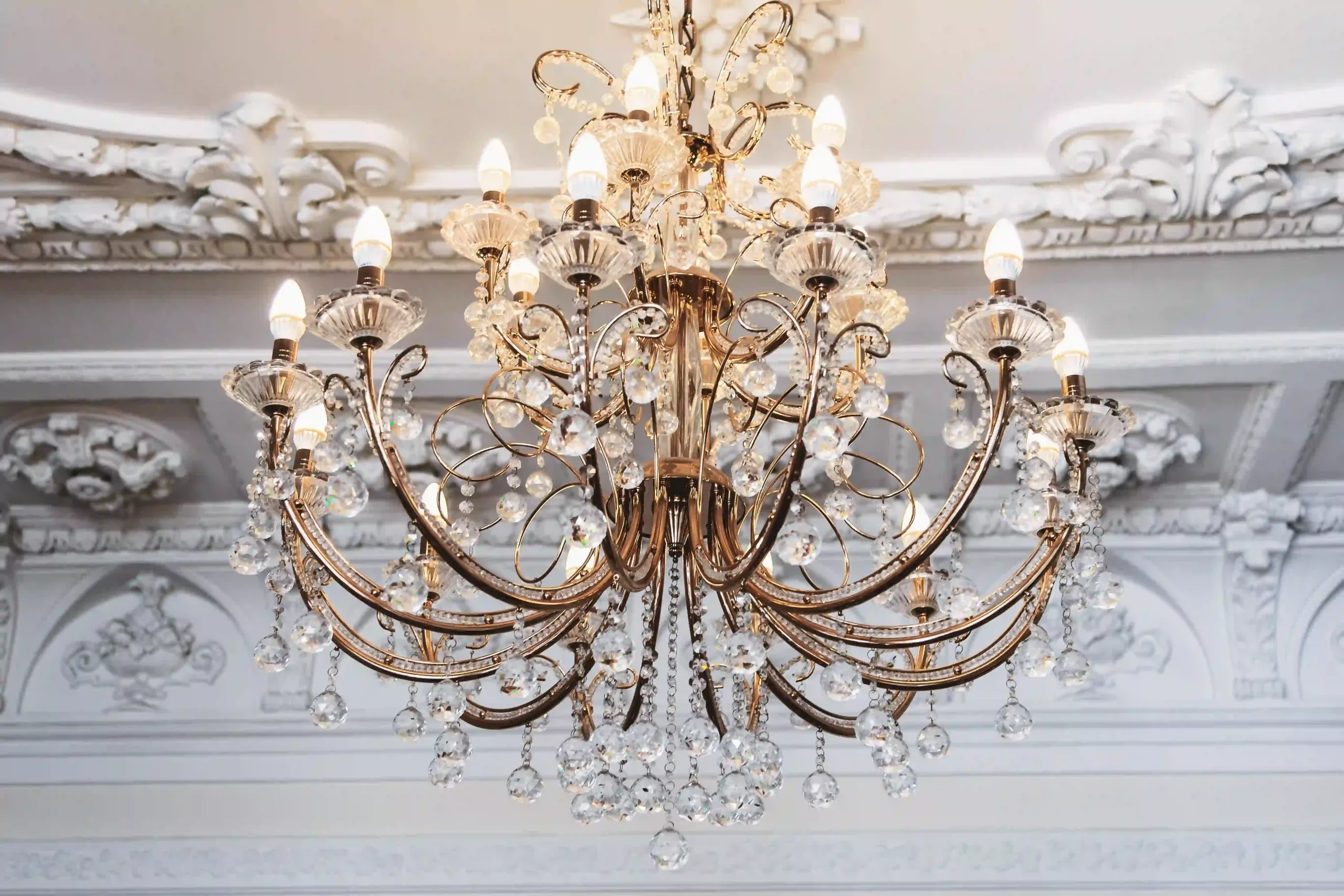 An Elegant Chandelier In A Foyer, Adding A Touch Of Luxury With Its Crystal Fixtures.