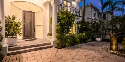 Illuminated Stone Path And Stairs Leading To A House Entrance At Sunset